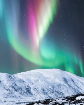 northern lights over snowy mountain